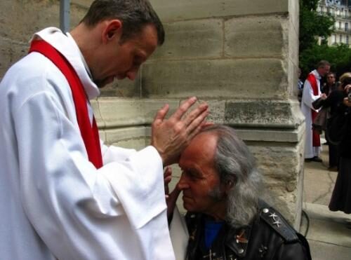 Le père Guy Gilbert reçoit la bénédiction d'un prêtre qui vient d'être ordonné